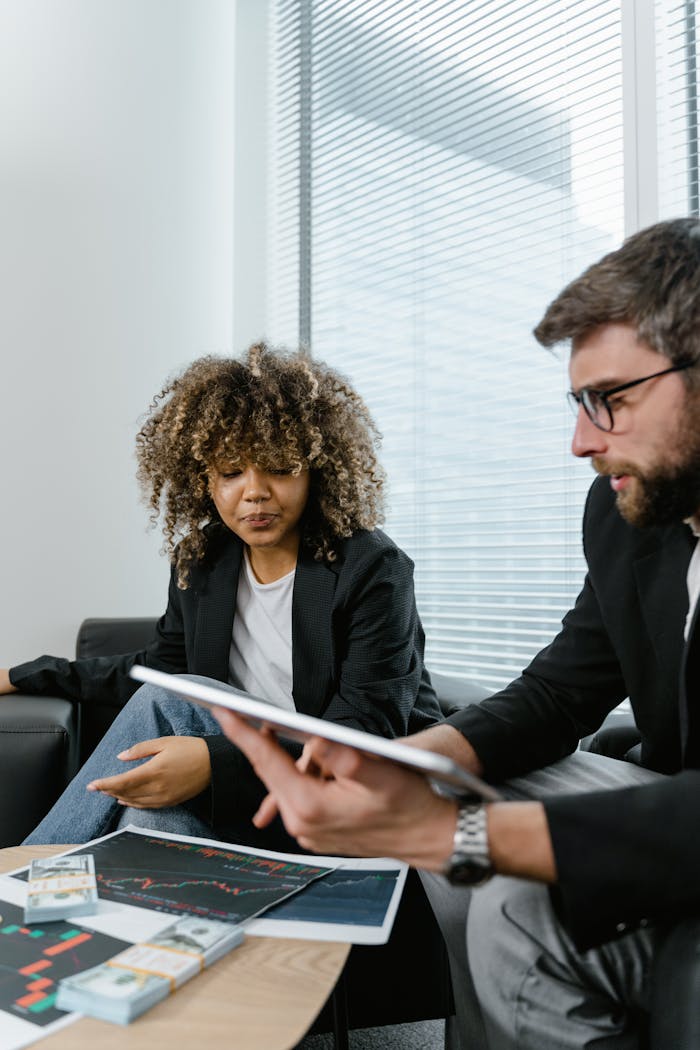 Crafting Captivating Headlines: Your awesome post title goes here Two professionals discussing financial graphs on a tablet in a modern office setting.